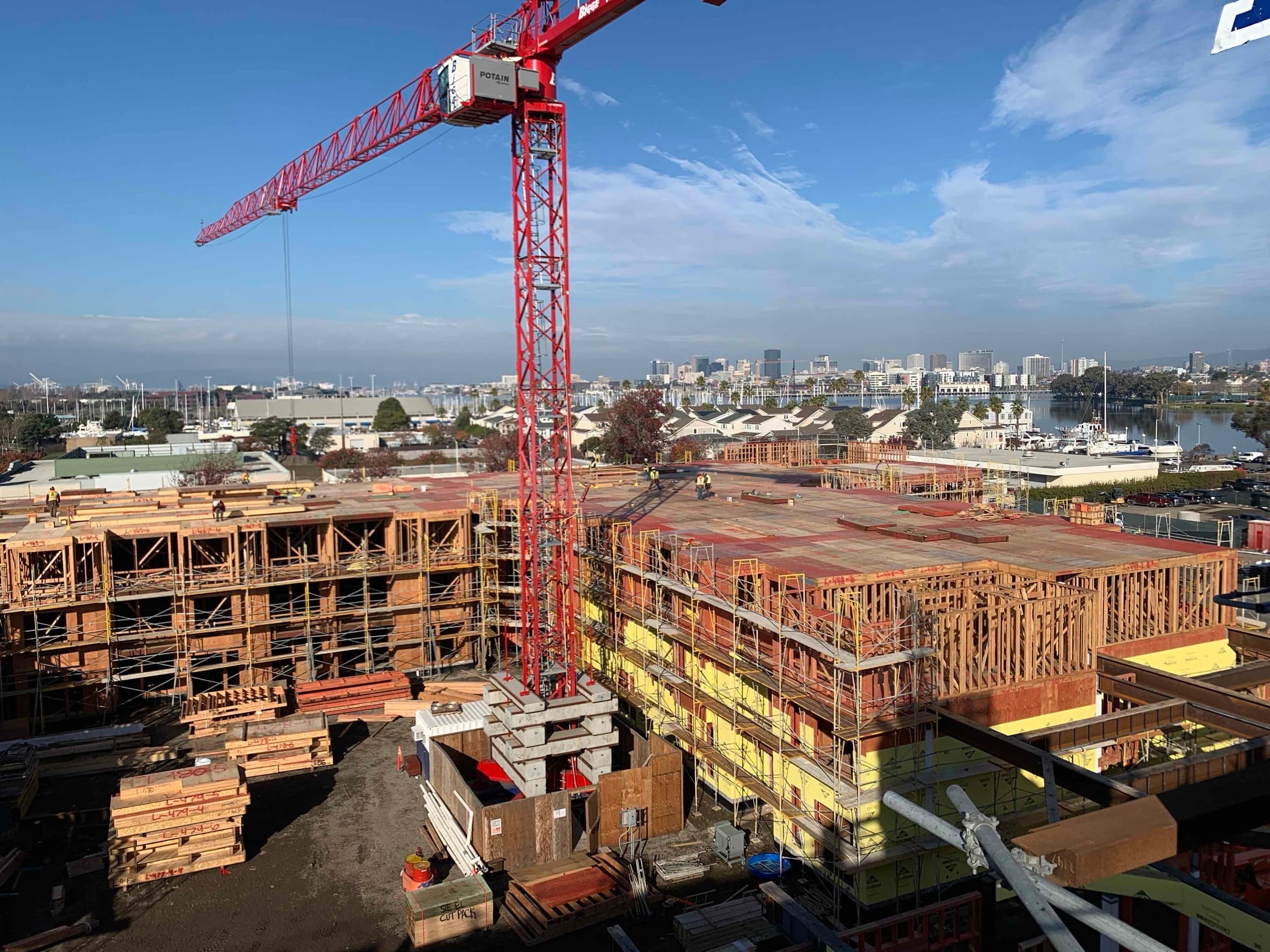 The Launch project with red tower crane and Oakland marina at sunset