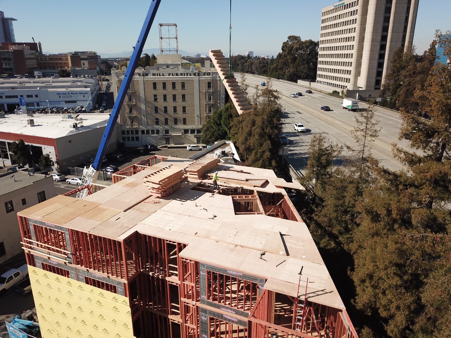 Aerial drone view of multi-story wood-frame building under construction