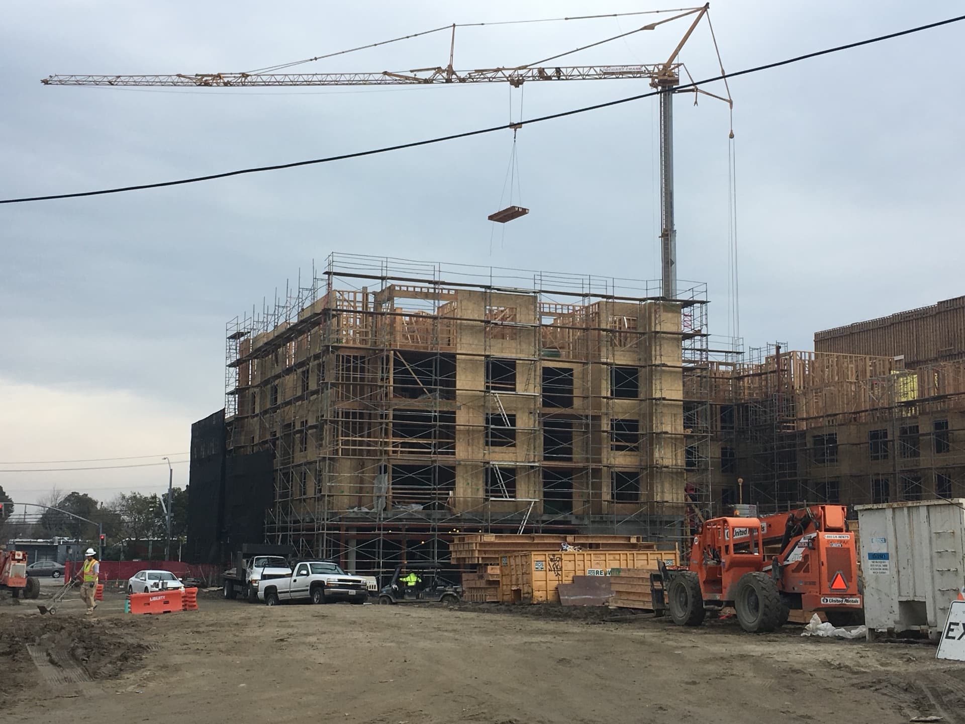 Floor cassette suspended from crane against blue sky