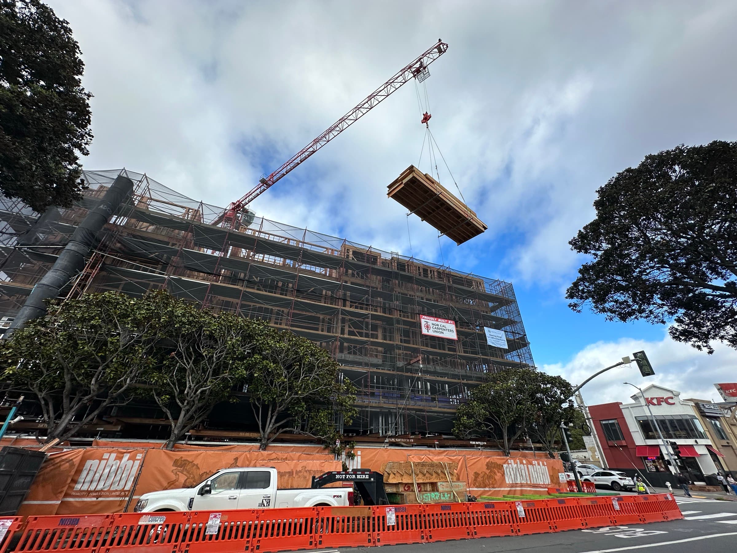 4200 Geary tower crane lifting floor cassette over multi-story building